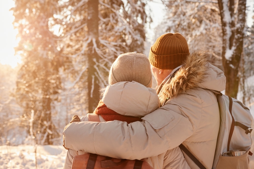 back of a mature couple in snow while they enjoy couples getaways in Wisconsin