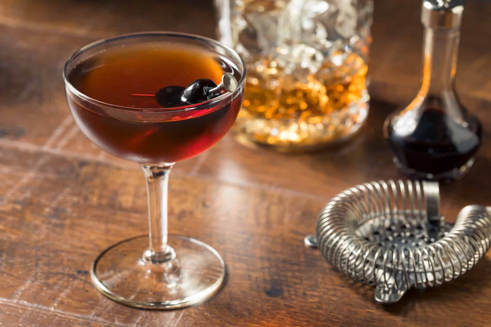 Dine at Nearby Wisconsin Supper Clubs 3 Refreshing Boozy Manhattan Cocktail with Vermouth and cherry garnish, what you'll find at a Wisconsin supper club.