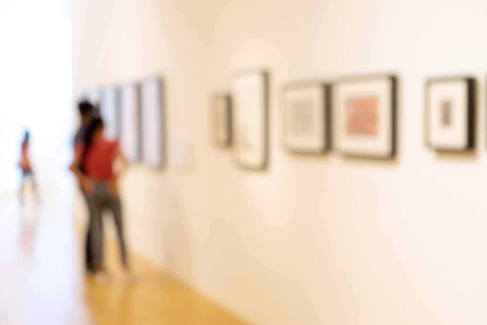 When deciding what to do in Wausau, WI, couples can enjoy local art galleries and museums. This couple admires art hanging on the wall. 