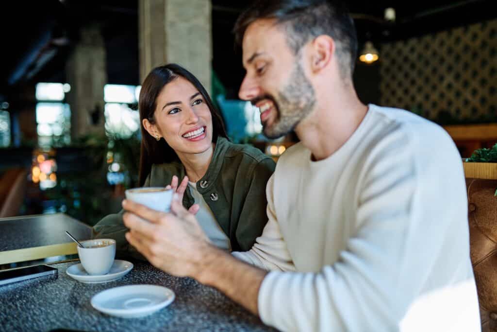 Coffee shop, happy and couple holding hands with drink, exploring romantic things to do in Wausau, WI.